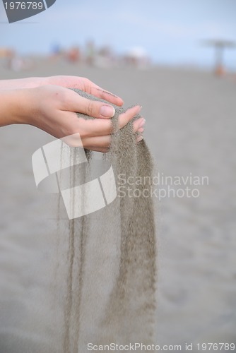 Image of fine sand leaking trought woman hands