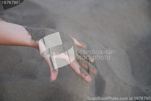 Image of fine sand leaking trought woman hands