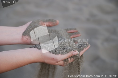 Image of fine sand leaking trought woman hands