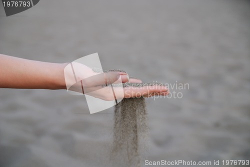 Image of fine sand leaking trought woman hands