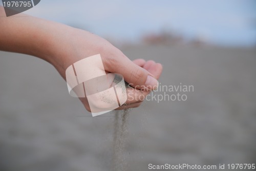 Image of fine sand leaking trought woman hands