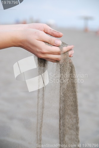 Image of fine sand leaking trought woman hands