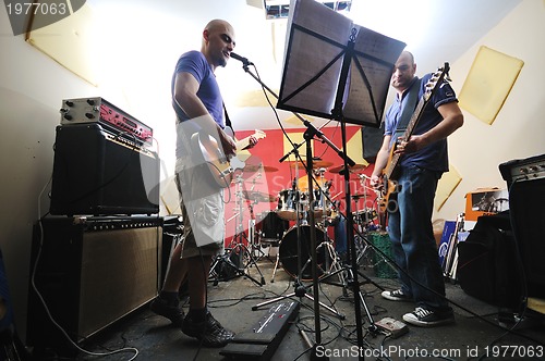 Image of music band have training in garage