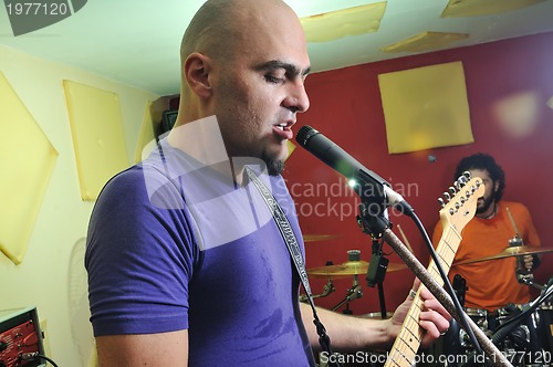 Image of music band have training in garage