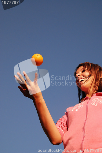 Image of female hand balancing iorange in air