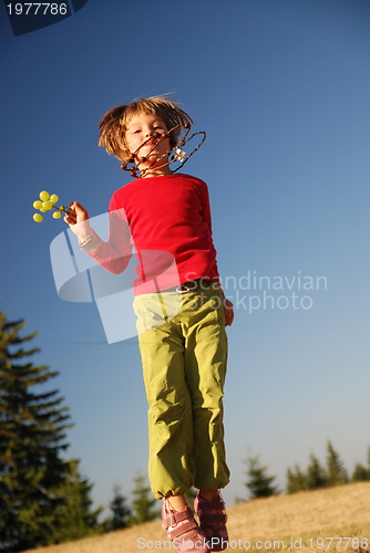 Image of happy child jumping in nature