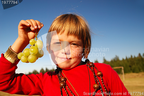 Image of happy girl with grape outside
