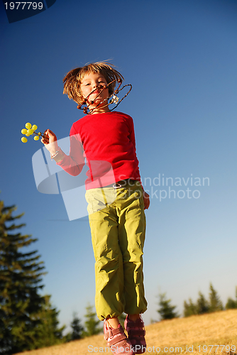 Image of happy child jumping in nature