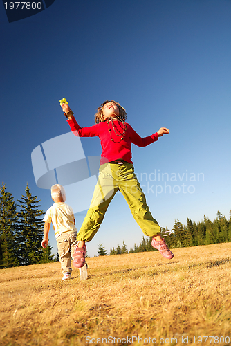 Image of happy child jumping in nature