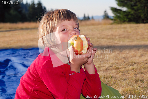 Image of the girl eating apple in nature