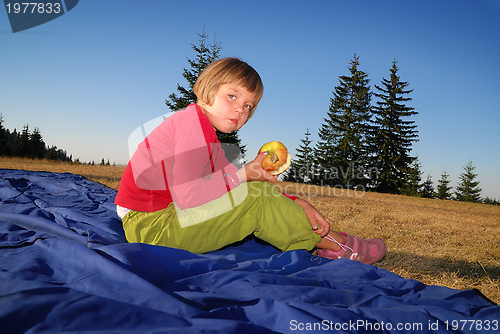 Image of the girl eating apple in nature