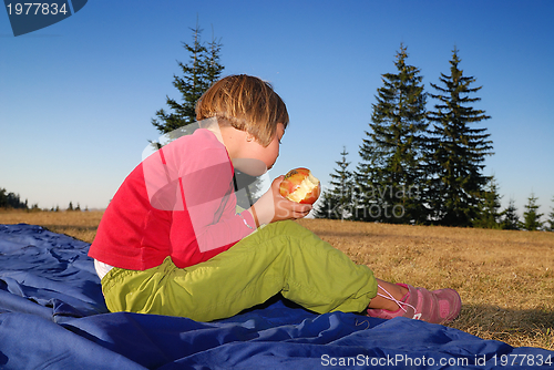 Image of the girl eating apple in nature