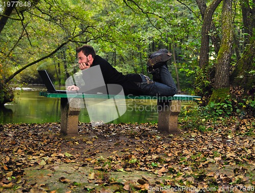 Image of young businessman working on laptop outdooryoung businessman out