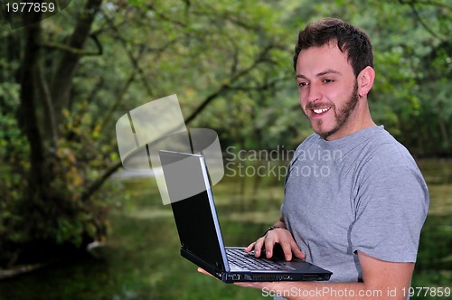 Image of young businessman with  laptop outdoor