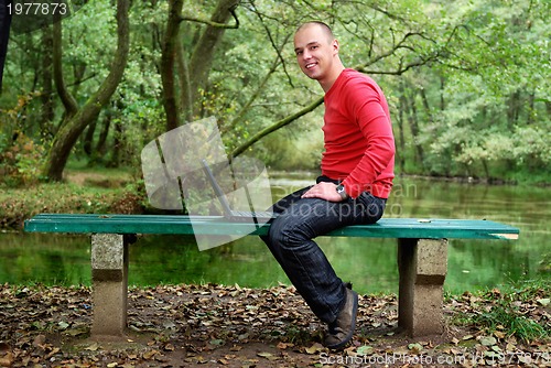 Image of young businessman in red shirt working on laptop 