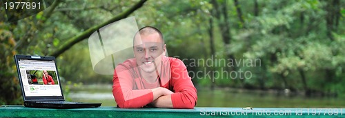 Image of young businessman in red shirt working on laptop 