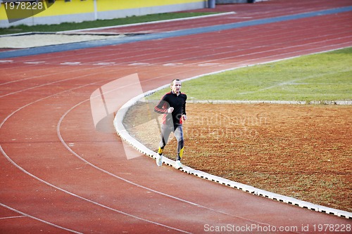Image of adult man running on athletics track