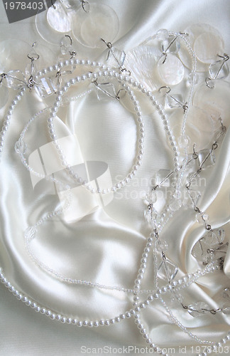 Image of White pearls and nacreous beeds on white silk as wedding backgro