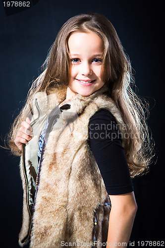 Image of  girl with fair long hair in fur vest on dark background