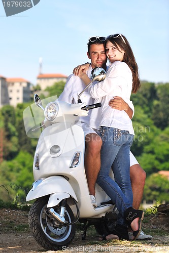 Image of Portrait of happy young love couple on scooter enjoying summer t