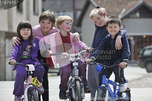 Image of happy childrens group learning to drive bicycle