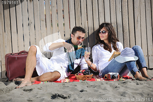 Image of young couple enjoying  picnic on the beach