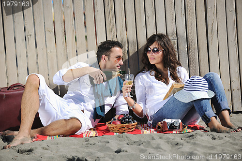 Image of young couple enjoying  picnic on the beach