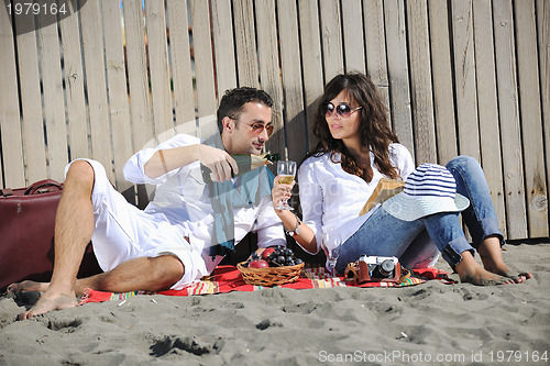 Image of young couple enjoying  picnic on the beach