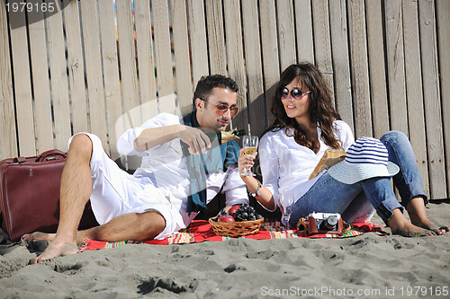 Image of young couple enjoying  picnic on the beach