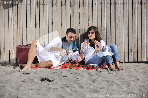 Image of young couple enjoying  picnic on the beach