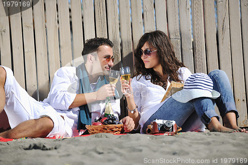 Image of young couple enjoying  picnic on the beach