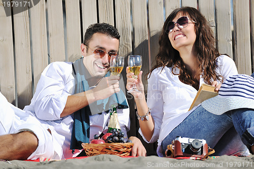 Image of young couple enjoying  picnic on the beach