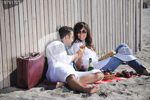 Image of young couple enjoying  picnic on the beach