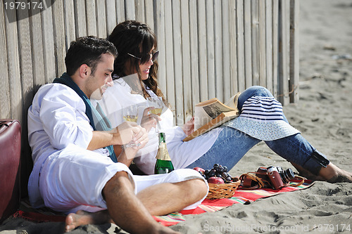Image of young couple enjoying  picnic on the beach