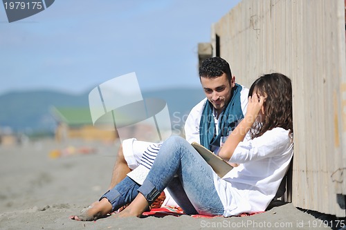 Image of young couple enjoying  picnic on the beach