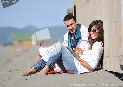 Image of young couple enjoying  picnic on the beach