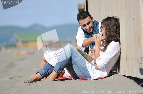 Image of young couple enjoying  picnic on the beach