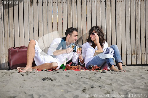 Image of young couple enjoying  picnic on the beach