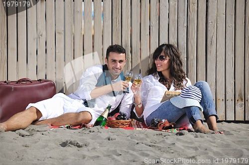 Image of young couple enjoying  picnic on the beach