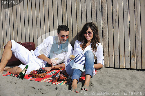 Image of young couple enjoying  picnic on the beach