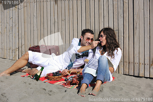 Image of young couple enjoying  picnic on the beach