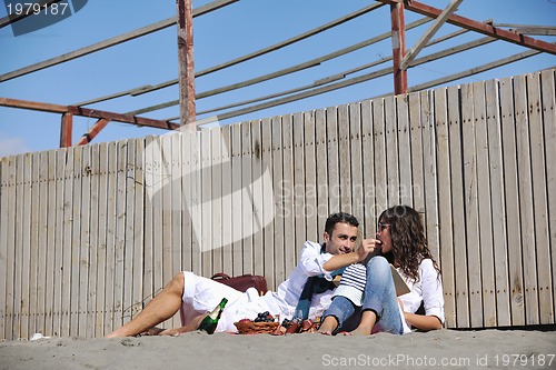 Image of young couple enjoying  picnic on the beach
