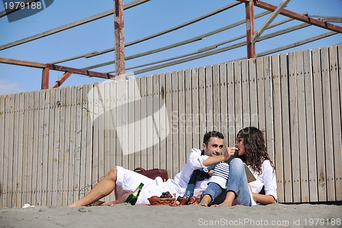Image of young couple enjoying  picnic on the beach