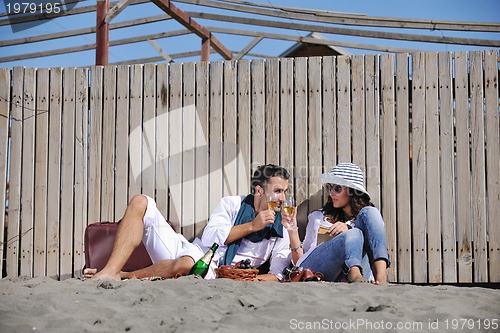 Image of young couple enjoying  picnic on the beach
