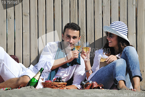 Image of young couple enjoying  picnic on the beach