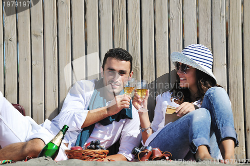 Image of young couple enjoying  picnic on the beach