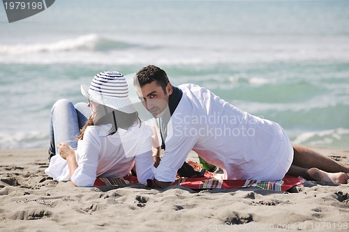 Image of young couple enjoying  picnic on the beach