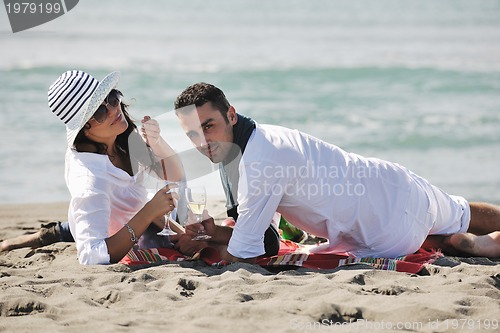 Image of young couple enjoying  picnic on the beach