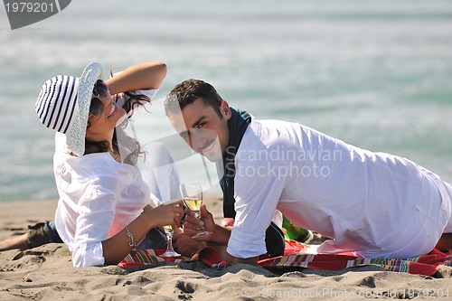 Image of young couple enjoying  picnic on the beach