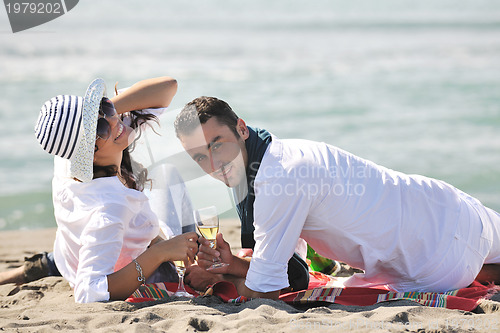 Image of young couple enjoying  picnic on the beach